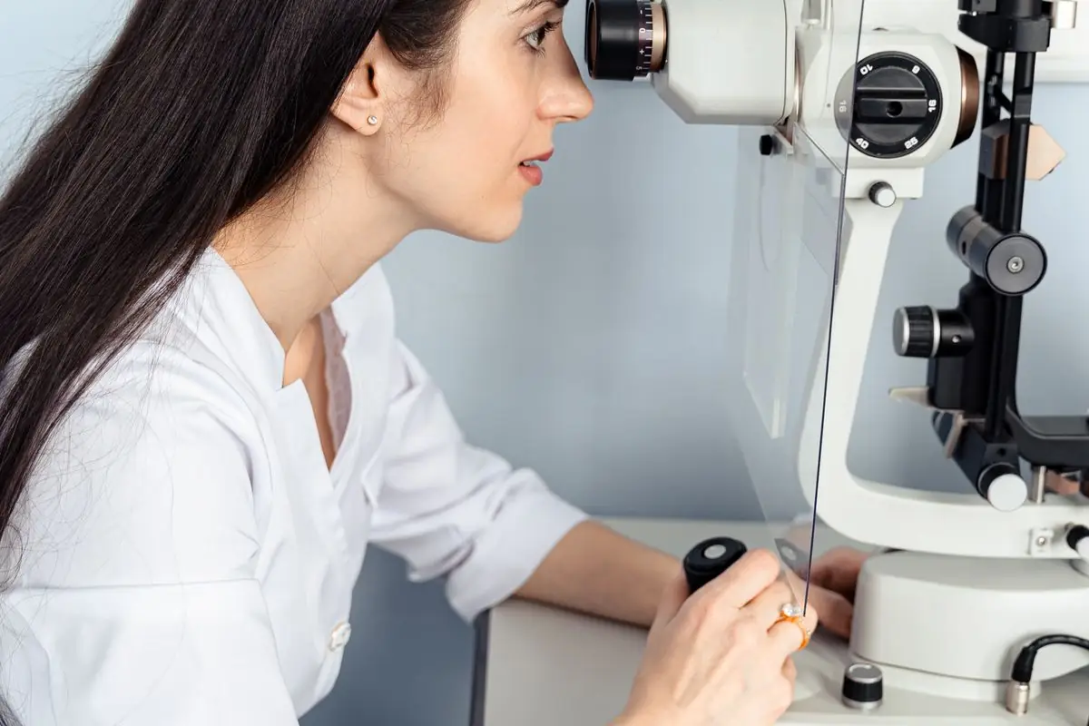 An optometrist examining a patient with a slit lamp